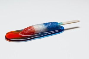 Red, white, and blue popsicle melting into a puddle