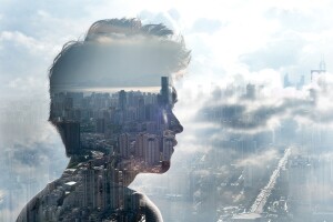 A transparent silhouette of a man against a cityscape. You can see the cityscape and clouds through his silhouette. 