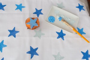 A pillowcase stamped with blue, white, and silver stars using a DIY potato stamp. Use this as a guide for DIY pillowcase projects for unique bedroom design. 