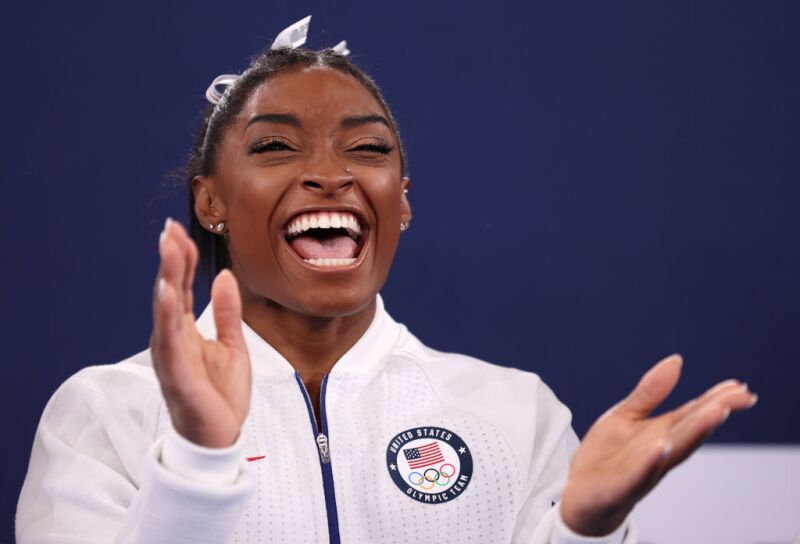 Simone Biles of Team United States joyfully cheers and claps during the Women's Team Final on day four of the Tokyo 2020 Olympic Games