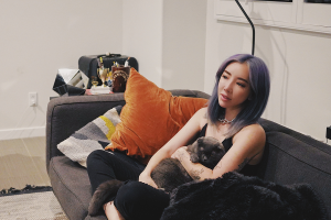 Music producer TOKiMONSTA holding with her cat in the living room