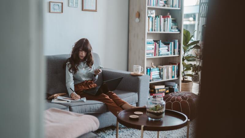 Woman creating a to do list in her living room