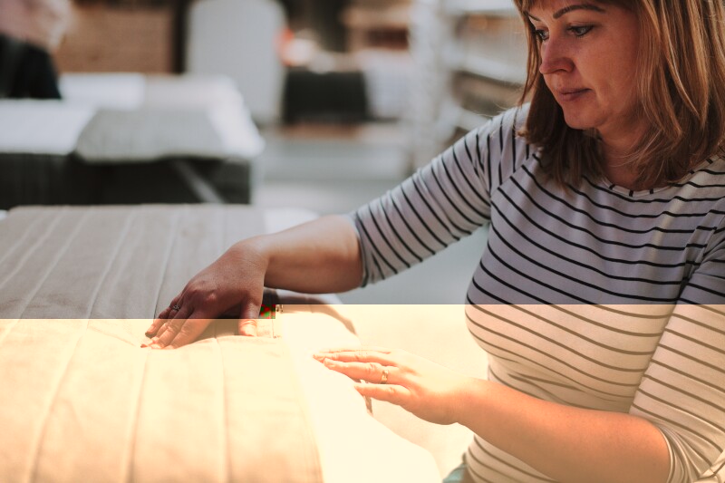 A woman choosing the right type of mattress protector.