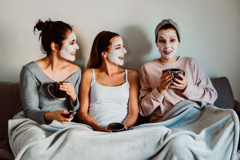 Three adults with face masks on, enjoying a cup of tea before bed