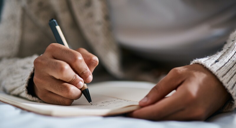 Close up of hands writing in a dream journal