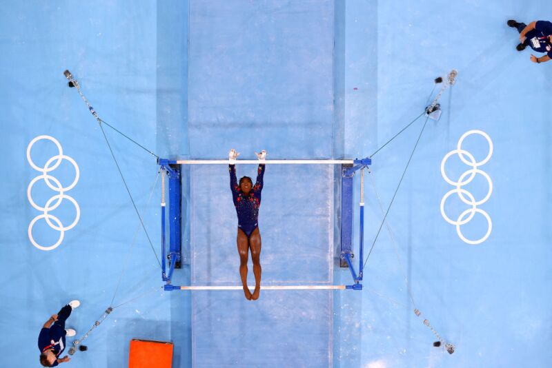 Simone Biles of Team United States competes on uneven bars during Women's Qualification of the Tokyo 2020 Olympic Games